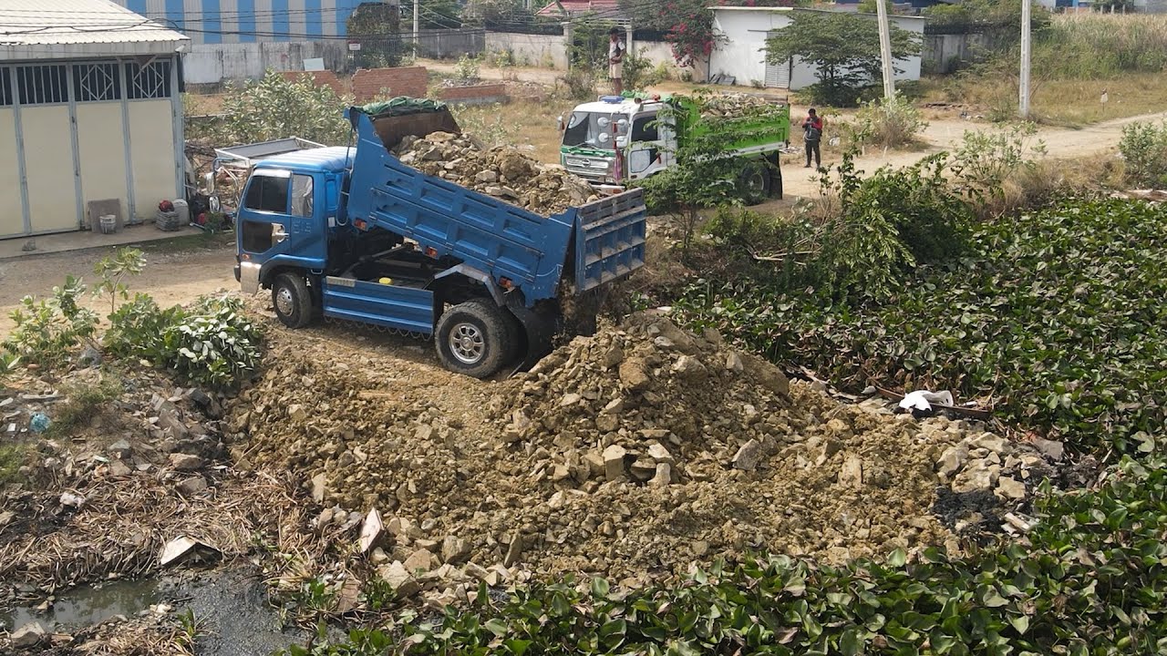 Move On Stone Into Flood Land By Bulldozer And Team Dump Trucks Dumping Process