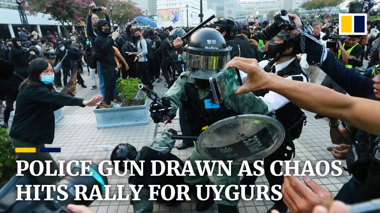 Police gun drawn as Hong Kong rally for China’s Uygurs descends into chaos