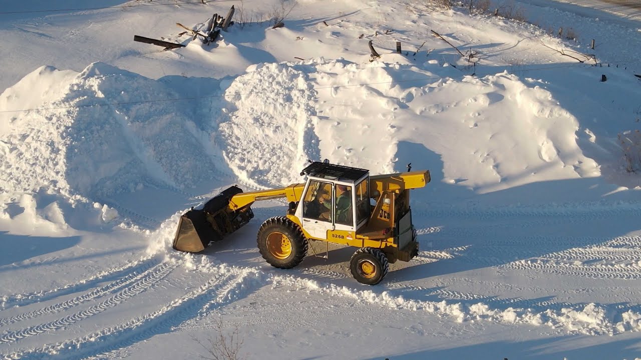 Fixing JCB telehandler bucket attachment and pushing snow.