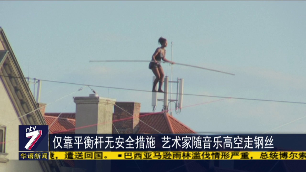 仅靠平衡杆无安全措施 艺术家随音乐高空走钢丝