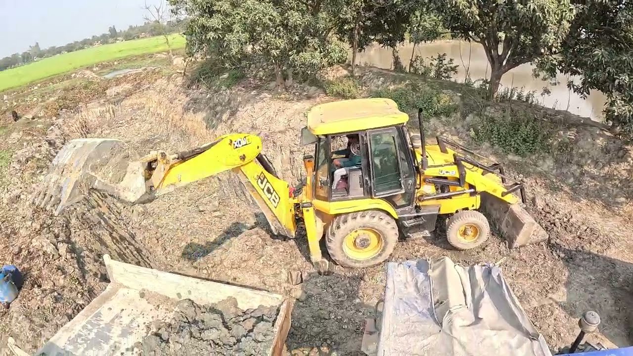 A JCB is working with many vehicles mixed together.