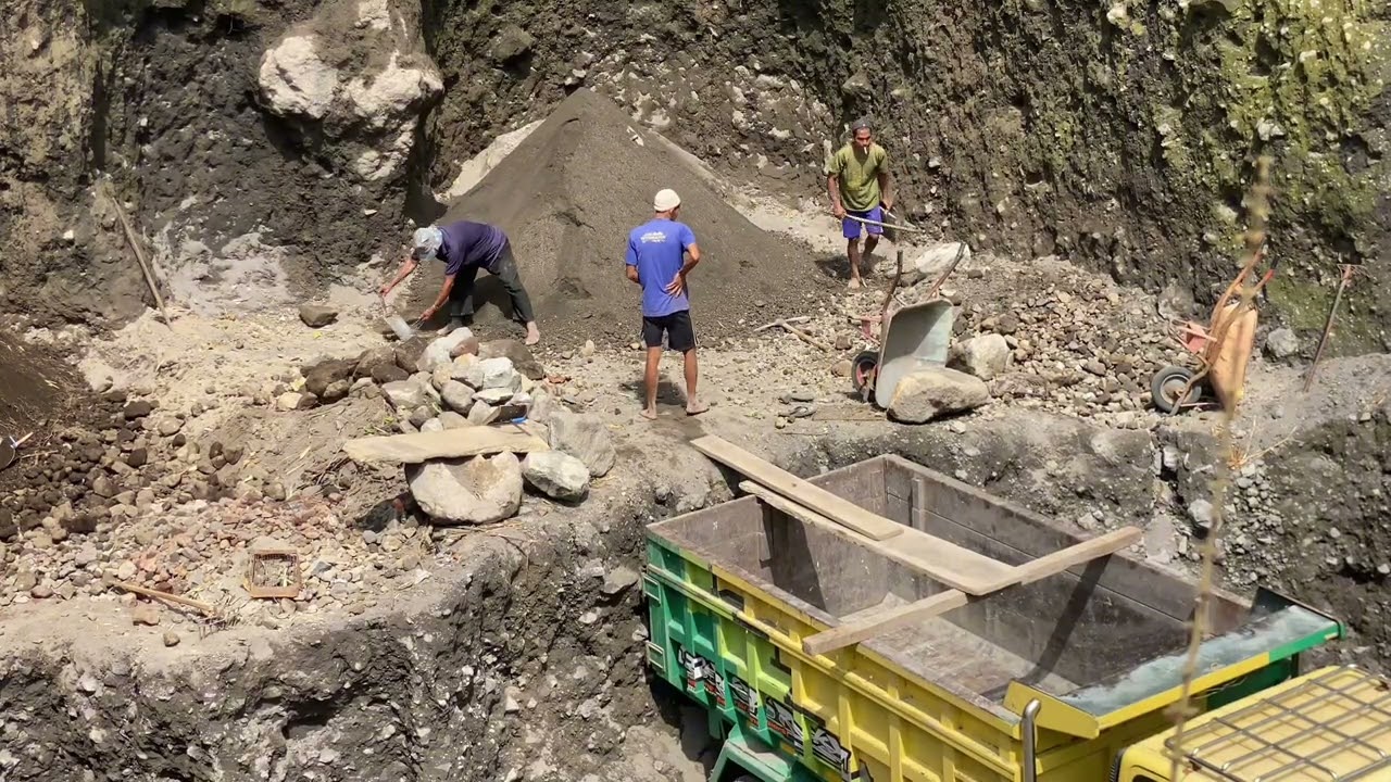After the miners dig up the sand, they continue to load it onto trucks.