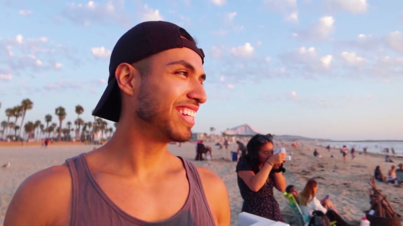 Man Taking A Picture On The Beach Full Of People