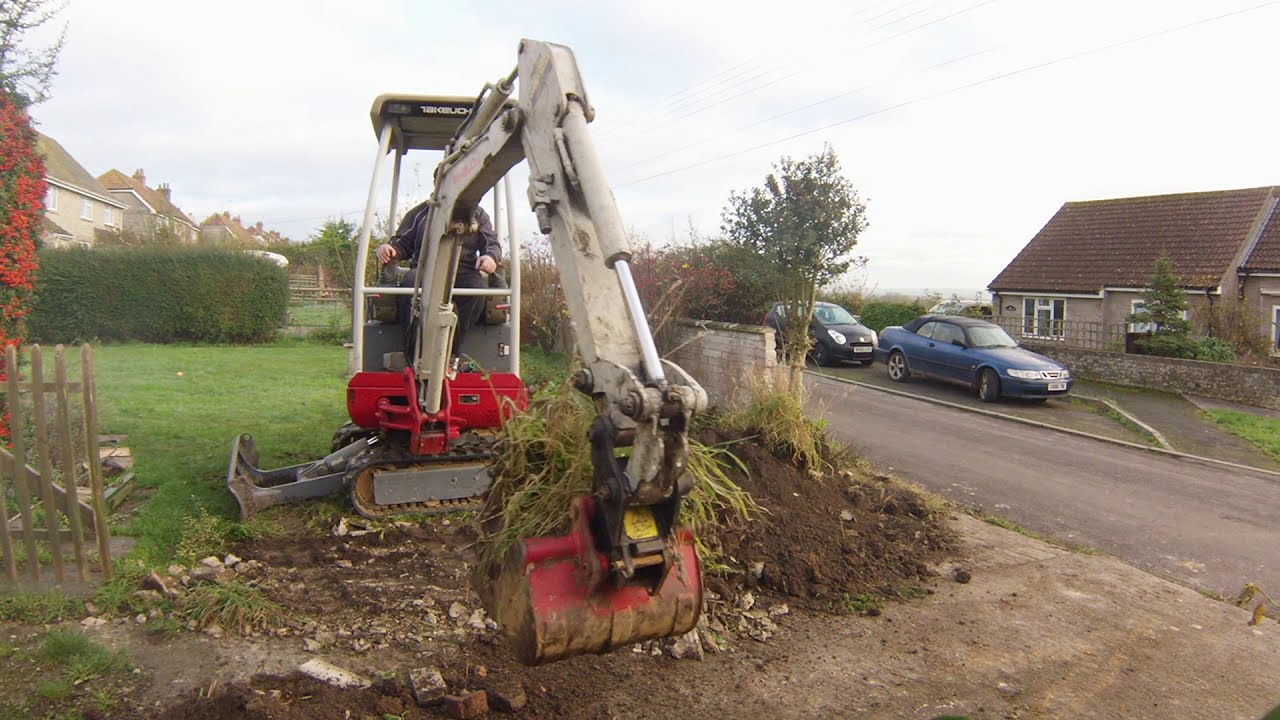 Digging out a driveway with a mini digger Takeuchi excavator