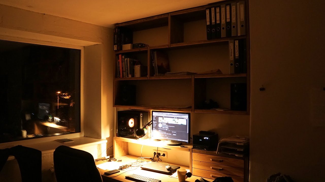 Building wooden shelf above big home office desk