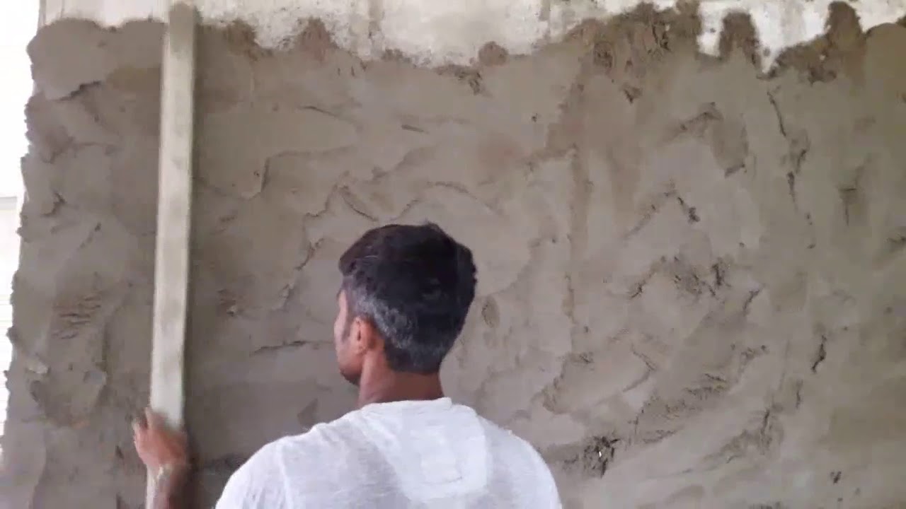 Applying wall plaster on concrete brick wall.