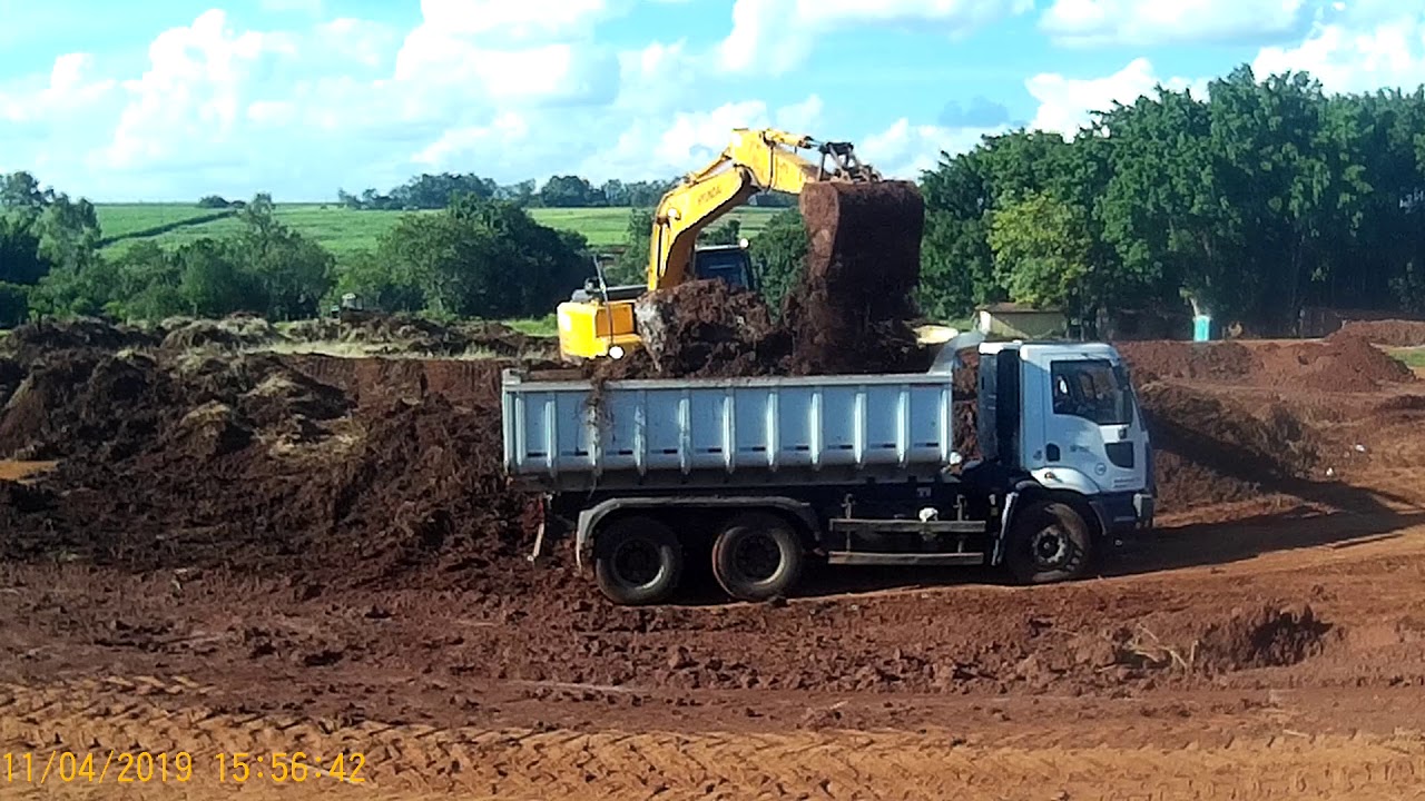 Escavadeira hidráulica carregando caminhões com sujeira