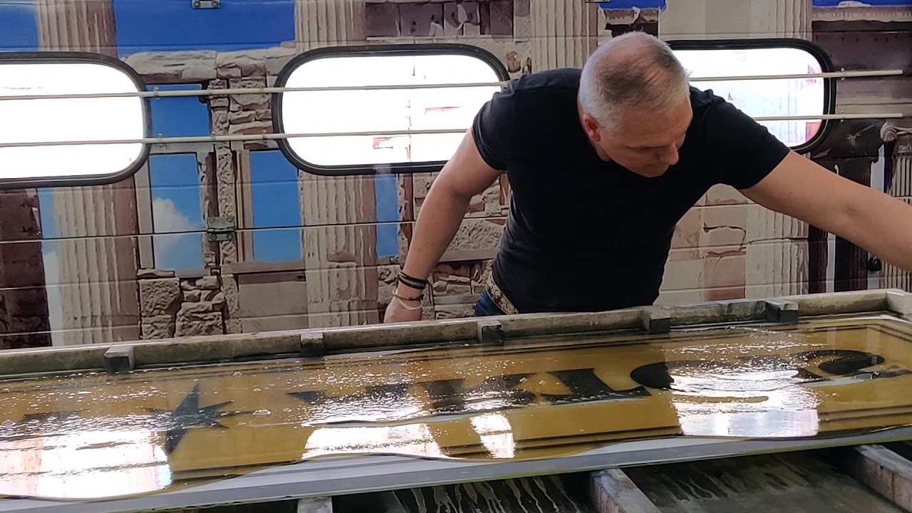 Pouring the animal glue on the glass surface for the glue chipping of this Stella Artois design.