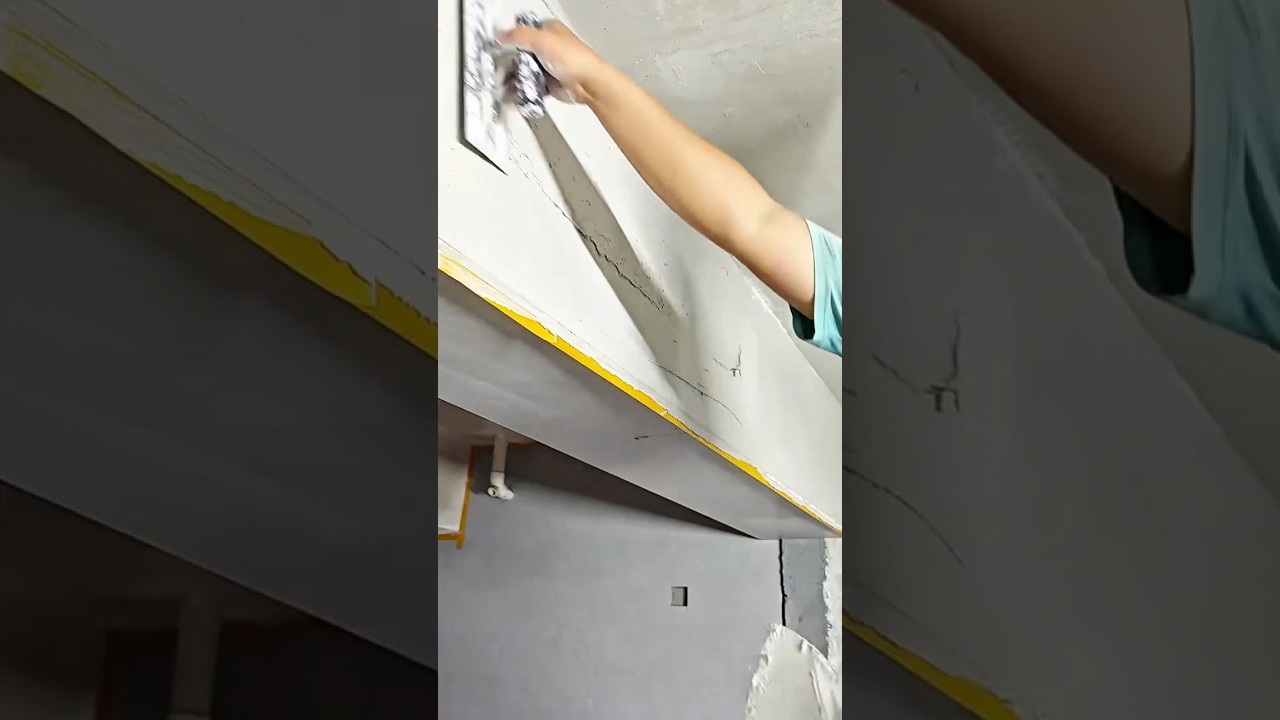 A Plasterer Using a Hand Trowel to Apply a Precision Base Coat of Plaster to an Interior Ceiling
