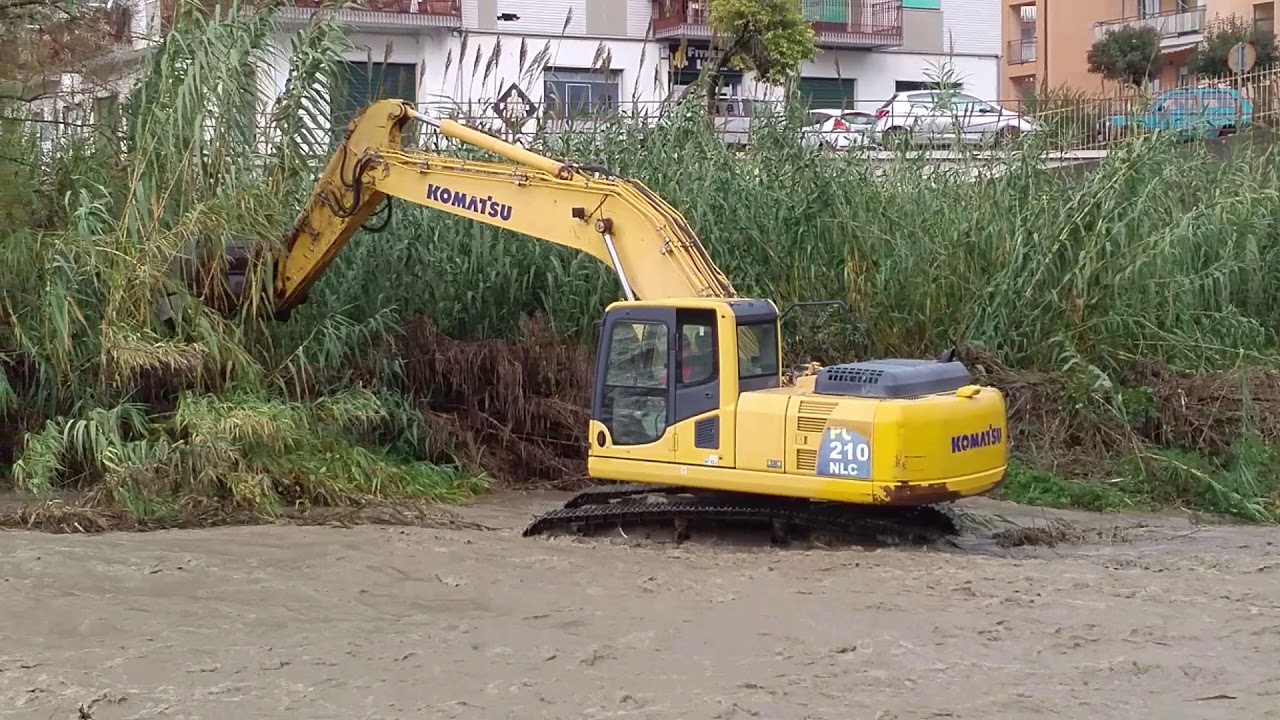 Ruspa al lavoro in mezzo all'acqua nel torrente Campagnano a Cosenza