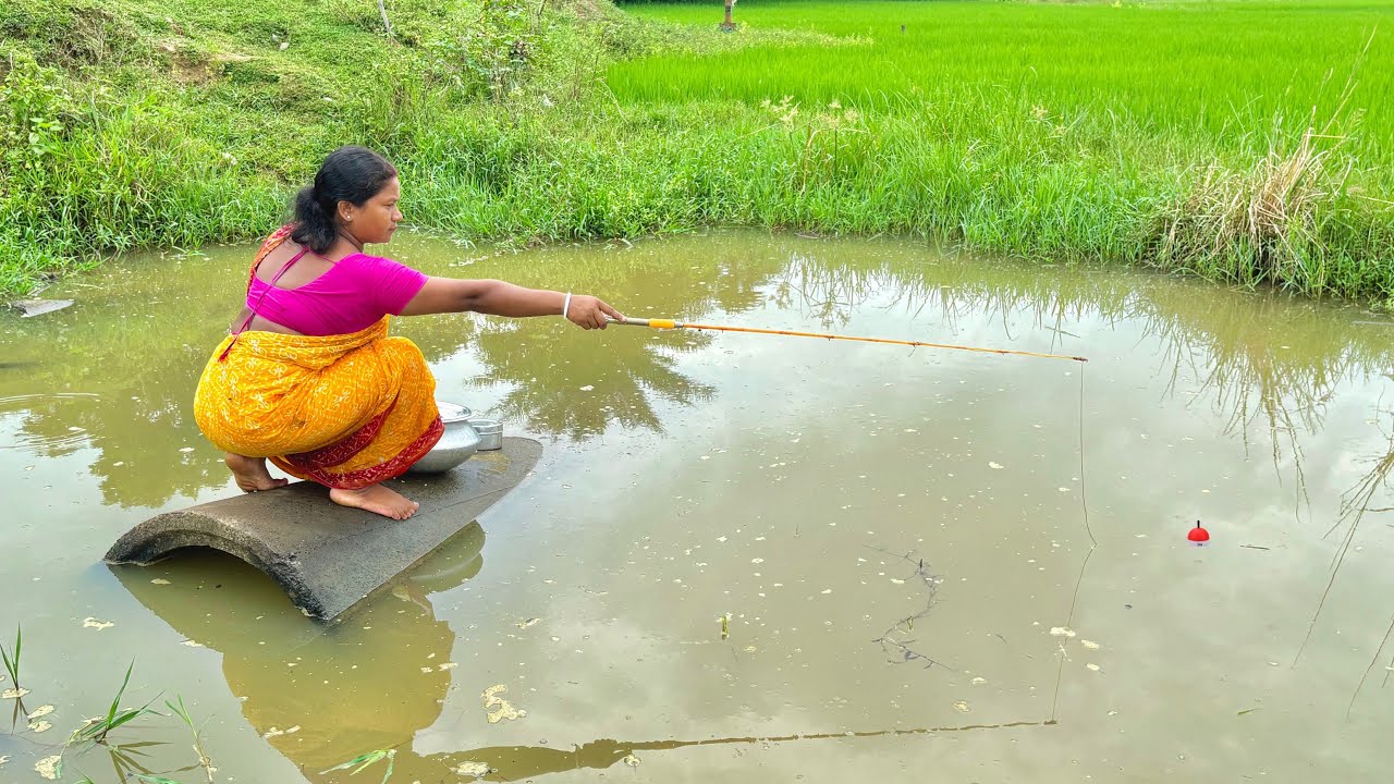 Fishing Video || The village woman sits in the water and catches fish with a hook from a large canal