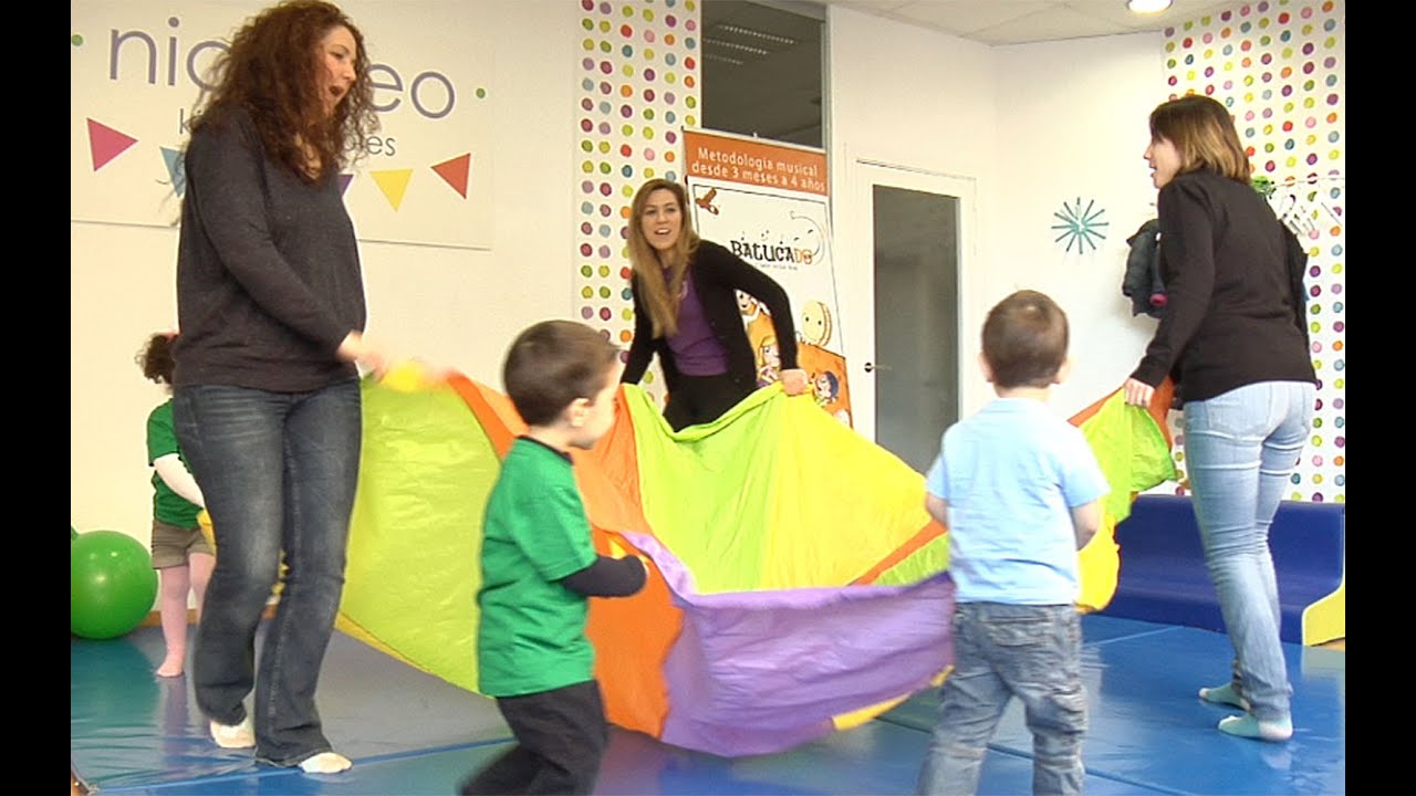 Juego de estimulación psicomotriz para los niños con un paracaídas