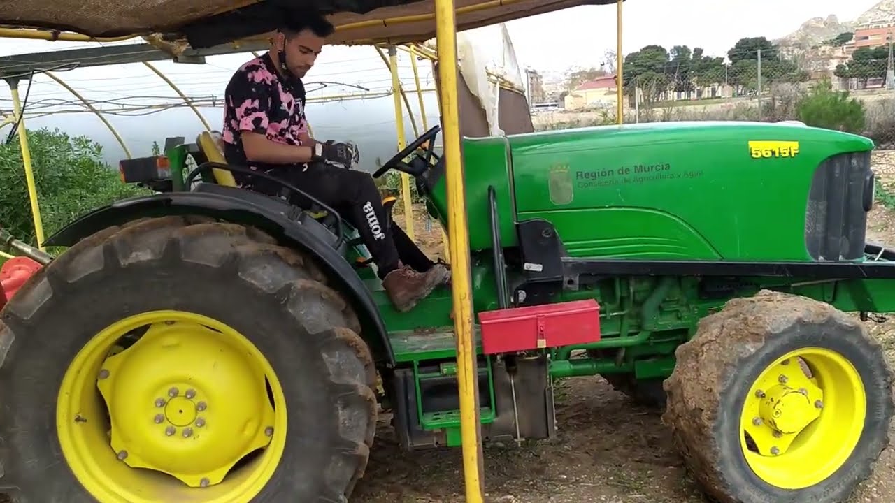 Tractor John Deere 5615F arrancando cultivos en invernadero