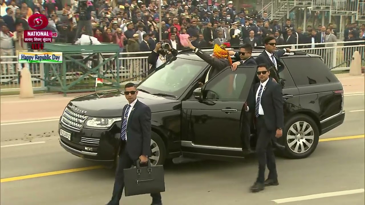 PM Narendra Modi enthusiastically waving at the crowd, accepting the greetings of the audience.