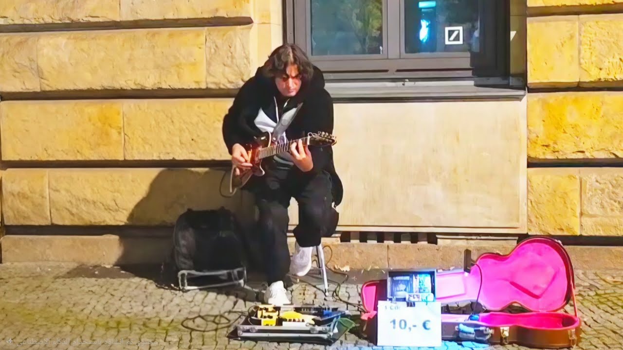 A professional guitarist plays in the street during the Berlin Festival of Lights.