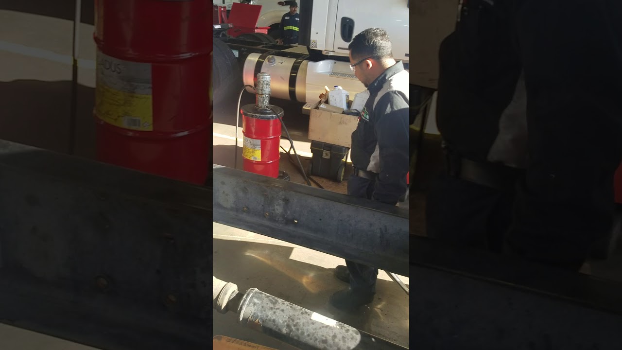 Greasing up a drive shaft on a freightliner.