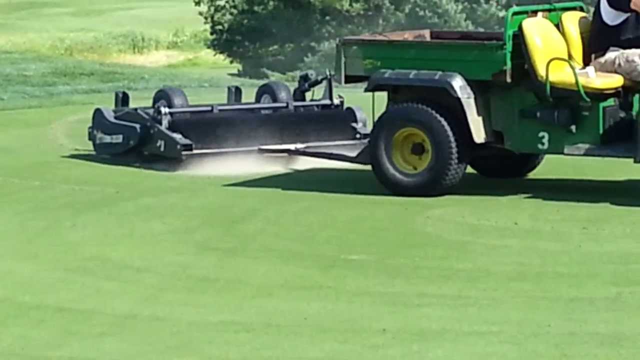 Golf Course greens aeration - brushing in the sand