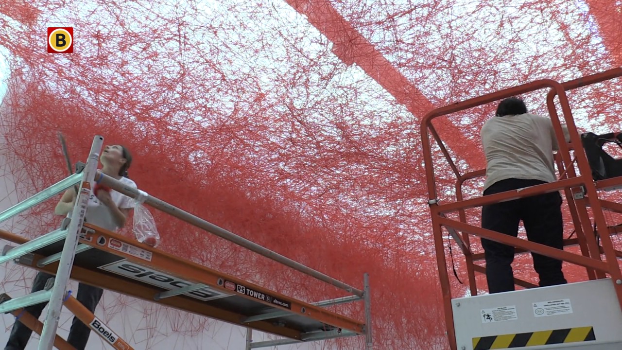 De Japanse kunstenares Chiharu Shiota bouwt een installatie van 2000 bolletjes rode wol voor het ...