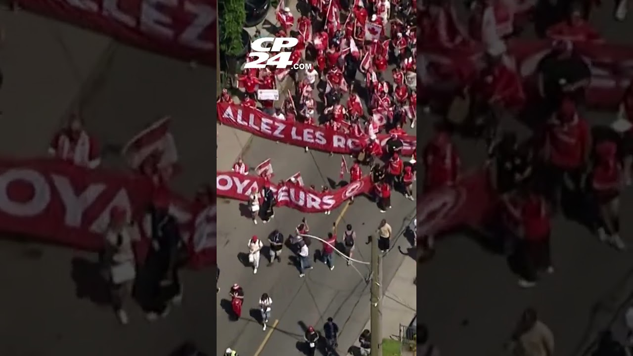 Fans decked out in red march through the streets of Toronto ahead of World Cup match