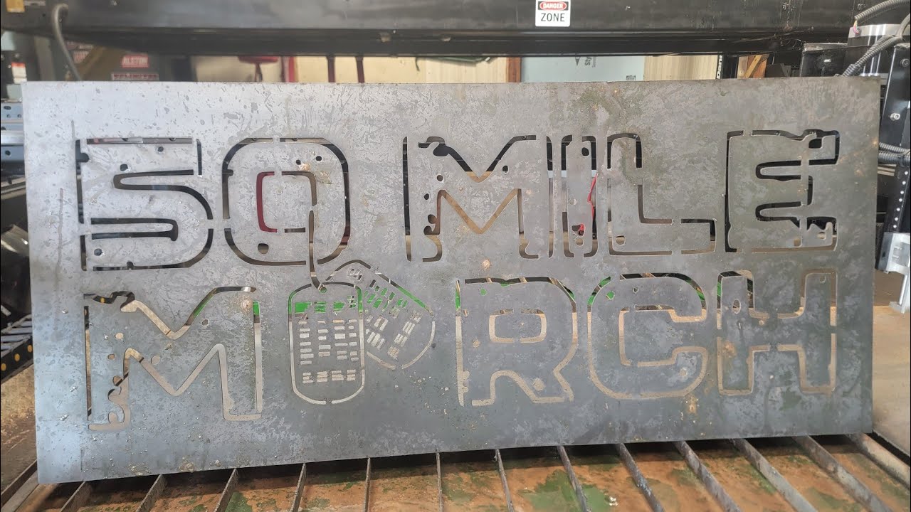 Plasma cutting a 50MileMarch sign.