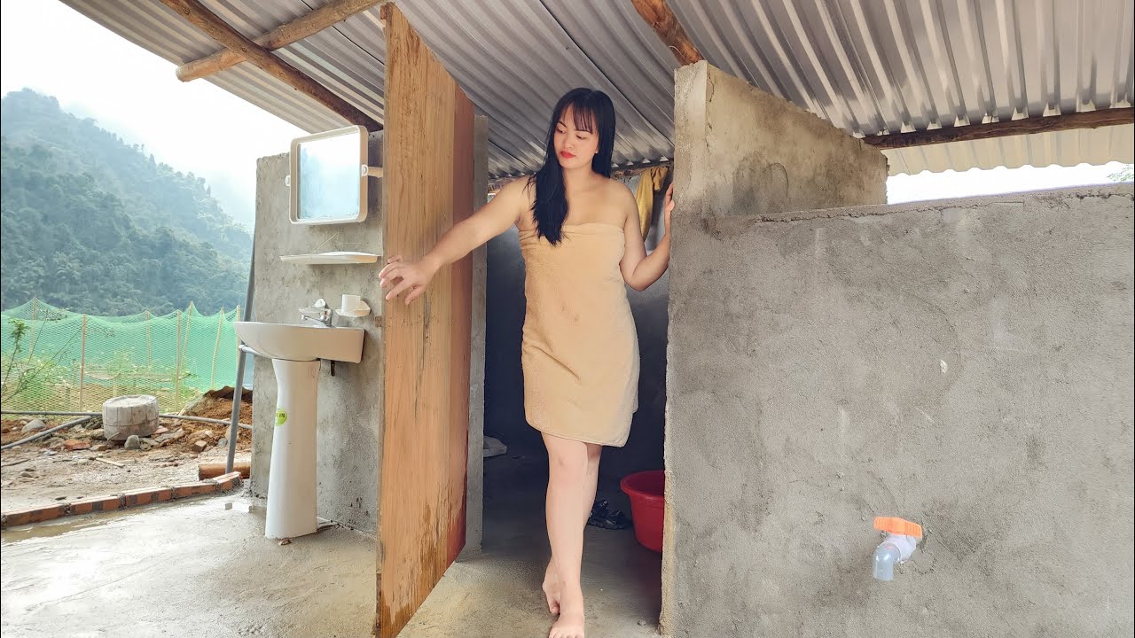 Completing the bathroom's corrugated iron roof, making wooden doors, and showering and shampooing