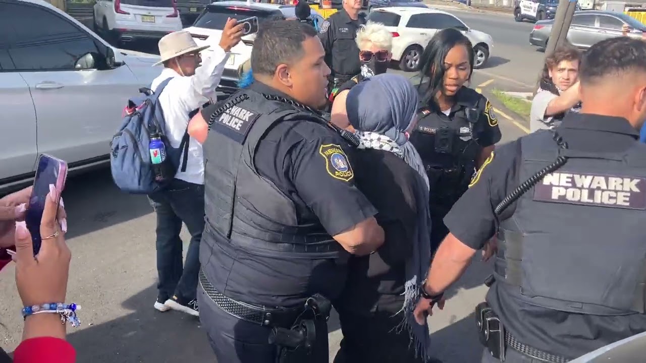 Protesting clergy at the ICE detention facility in Newark seen locking arms, blocking gate