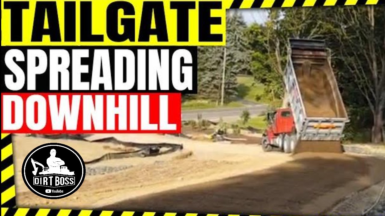 Dump truck tailgate spreading stone down steep grade Tri-County  Excavating