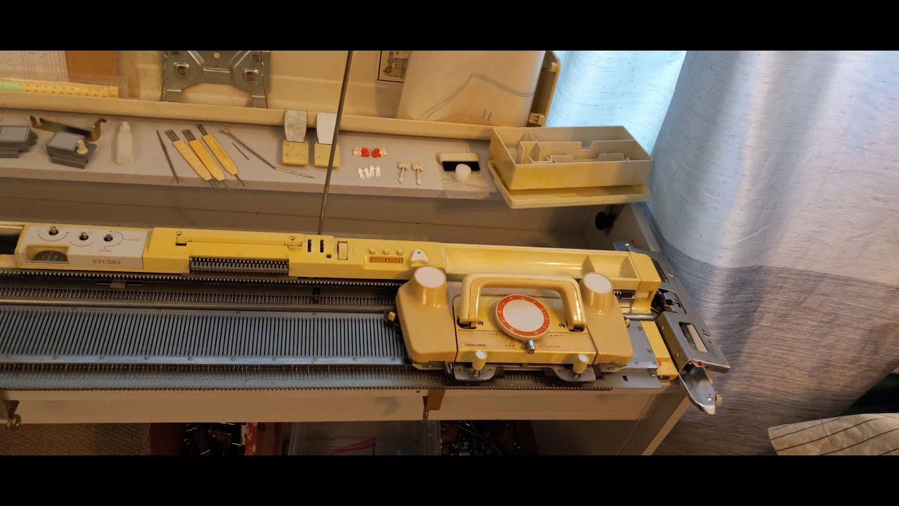 Studio 326 knitting machine with punch card patterning mechanism and built in knit leader.