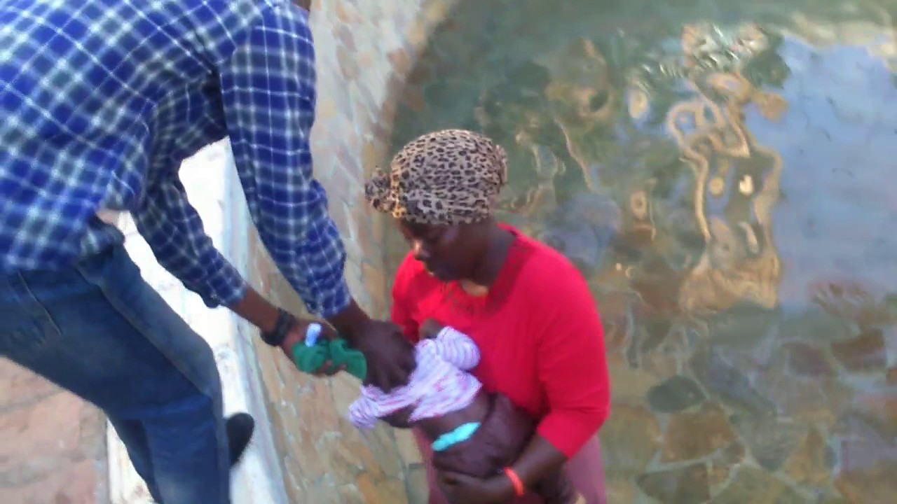 Pastor Paul Sanyangore heals a child at Bethesda Pool