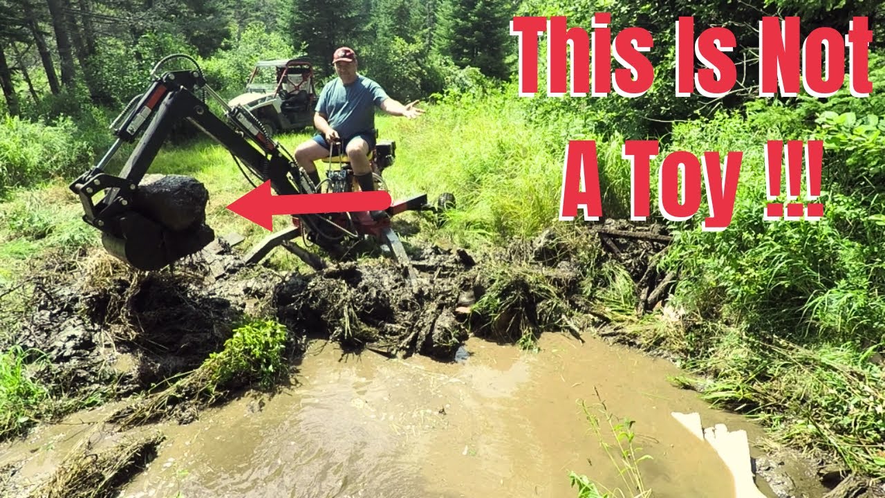 Red Rock Mini Backhoe being put to work digging a drainage ditch