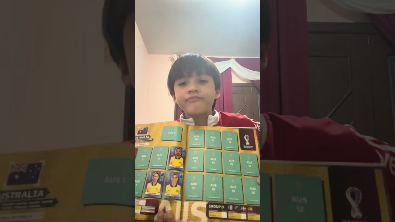 Yan mostrando o álbum da copa de 2022.