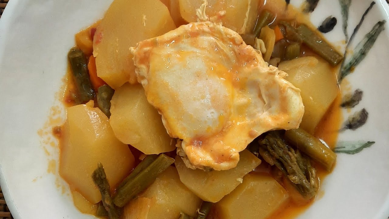 Cocina de la abuela, guiso de patatas con espárragos verdes y huevo cuajado.