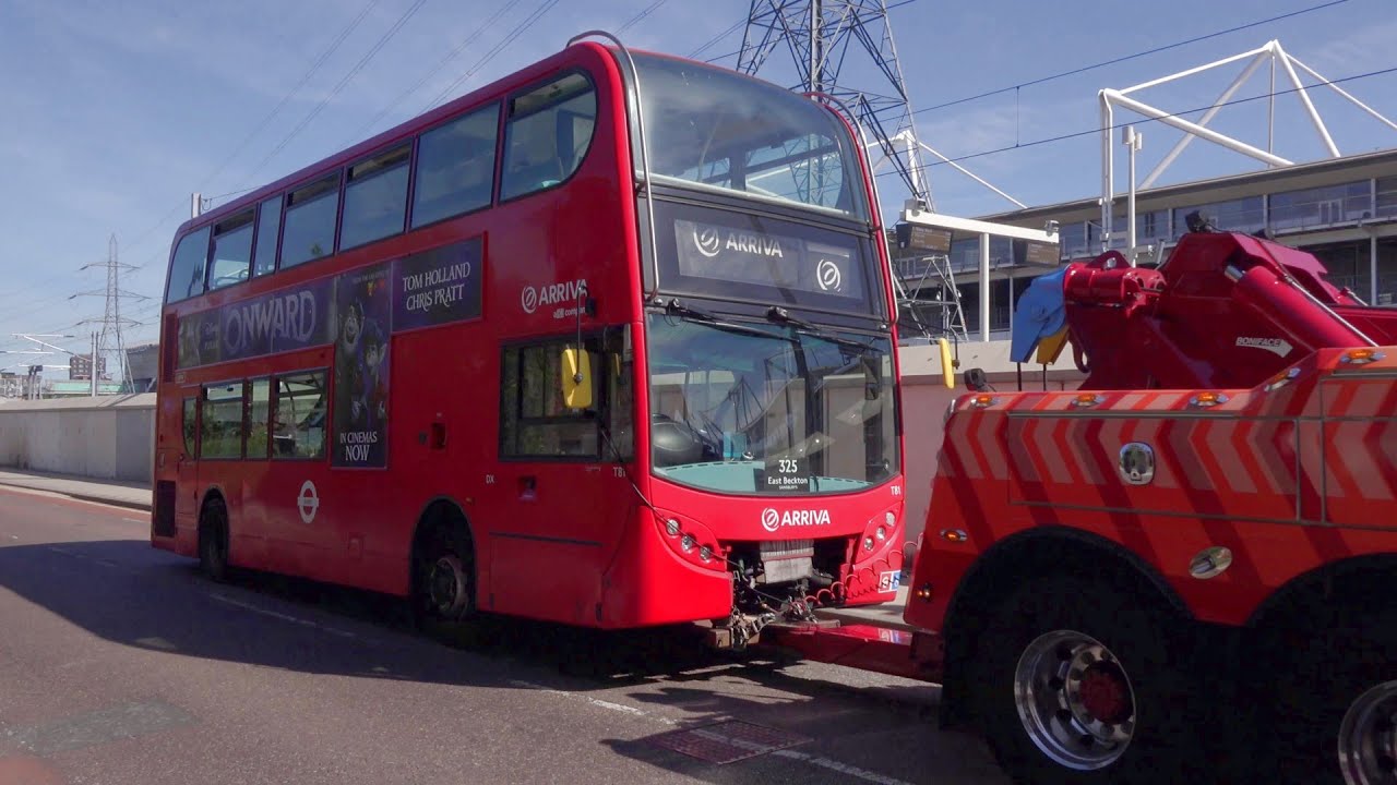 Three broken-down London buses being towed away.