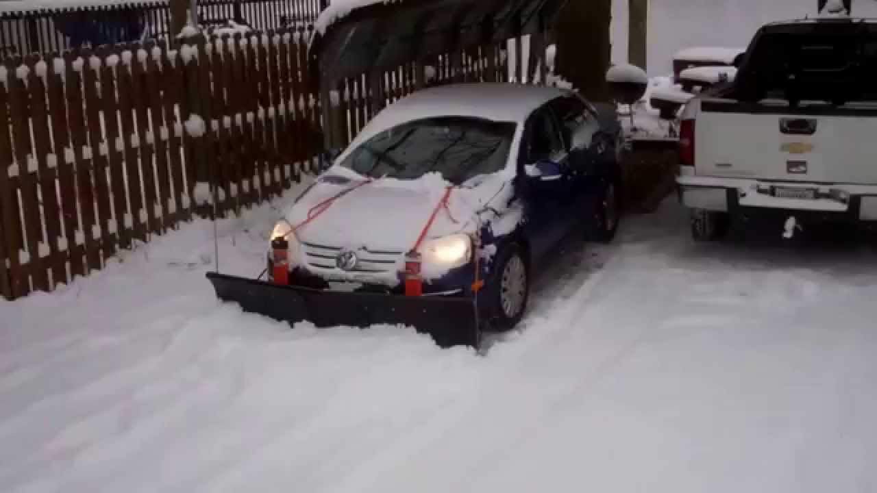 Nordic V-Plow on a Gravel Driveway Pushed by a Small Car