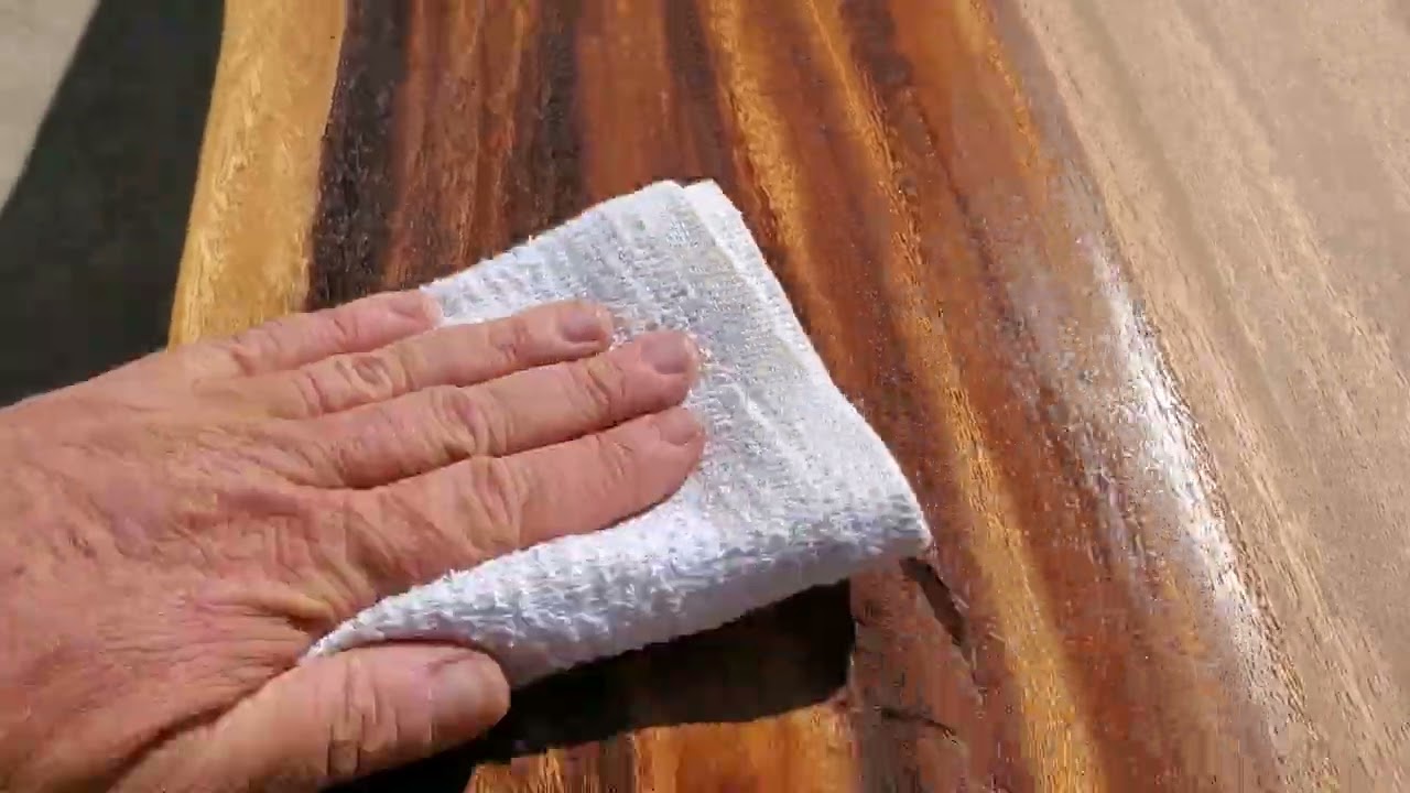 applying tung oil to acacia wood plank