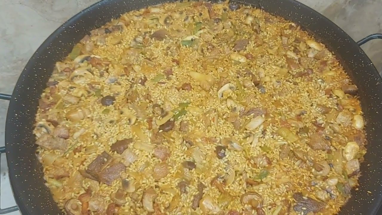 Paella de secreto, ajos tiernos y setas