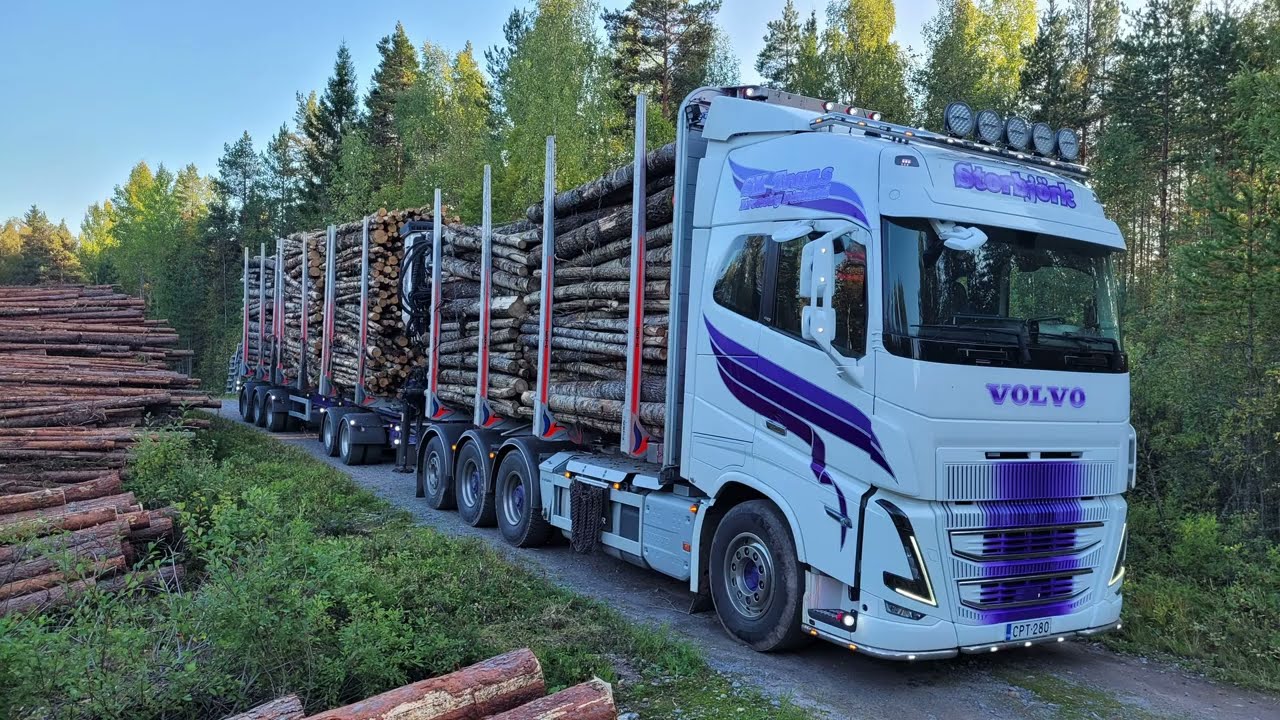Volvo timber truck unloading timber int a train carrier