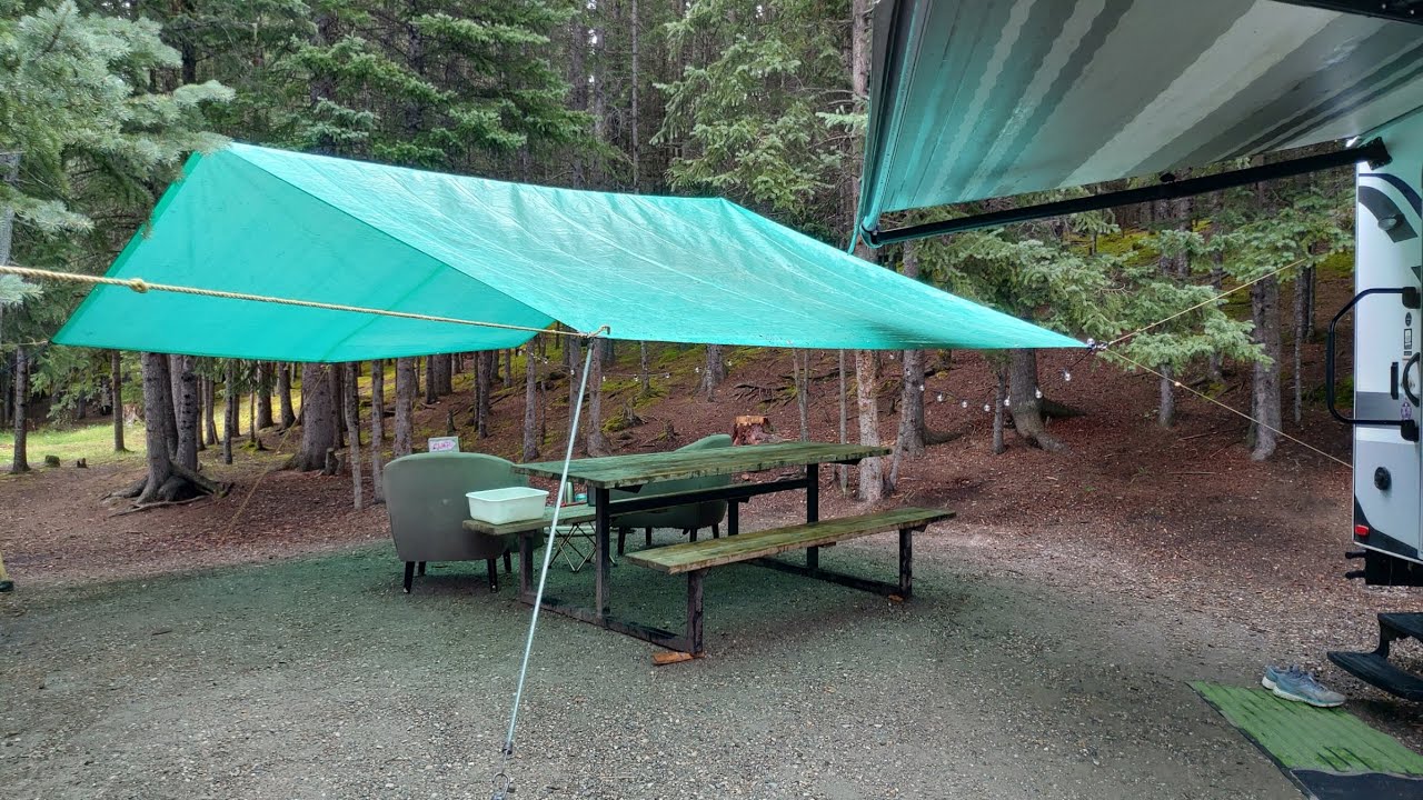 Setting up a Camping Tarp for a Living Space Complete with Firepit and Picnic Table when it Rains