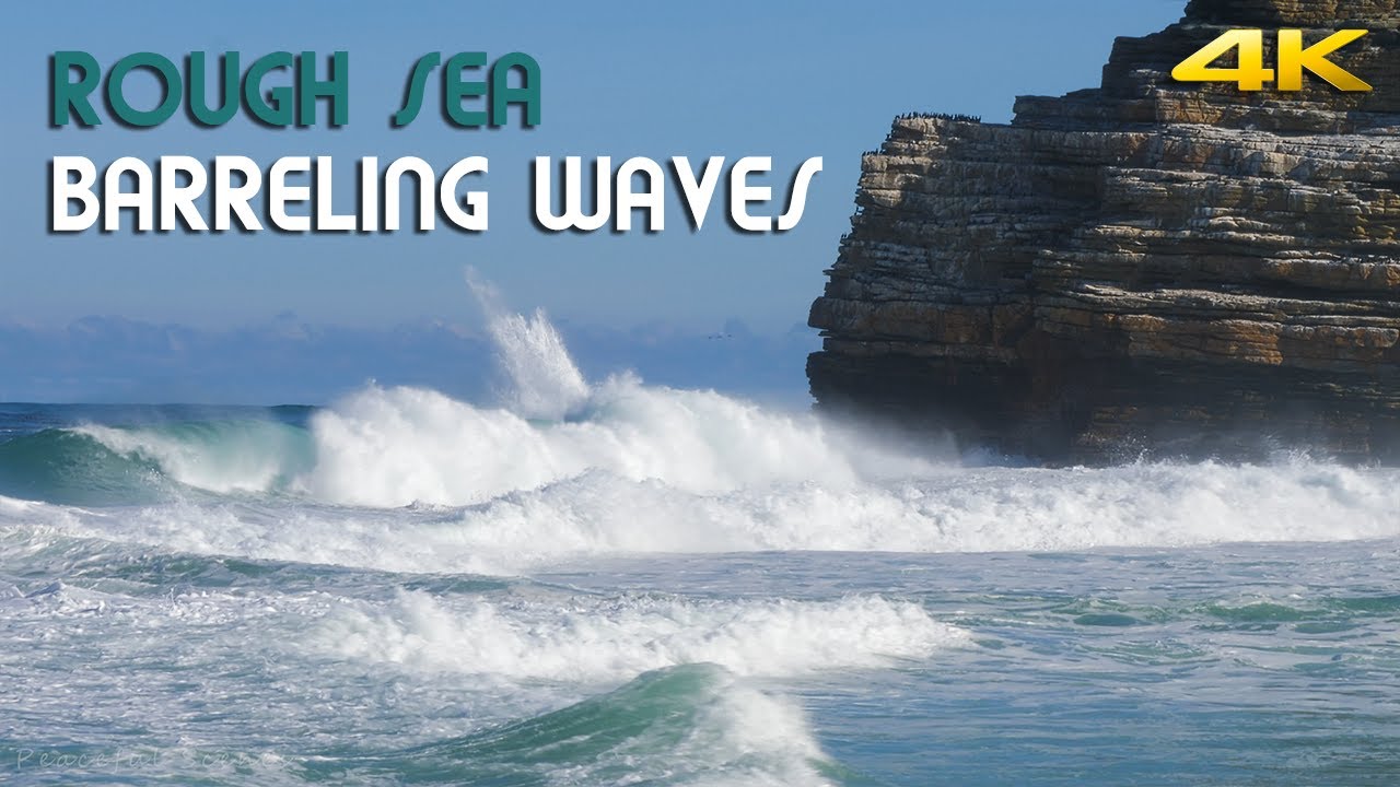 Big ocean waves barreling, crashing and thundering into a small beach | 4K Ultra HD video