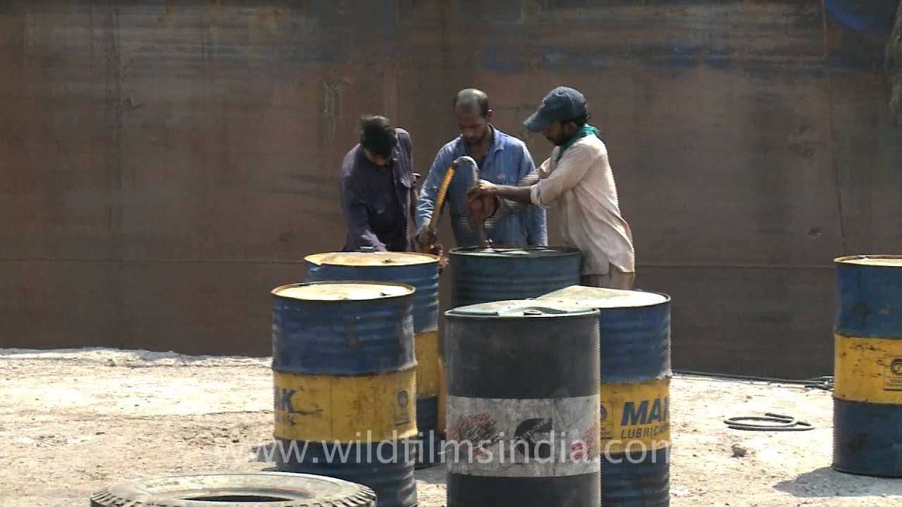 Pumping oil out of drums, Mumbai port