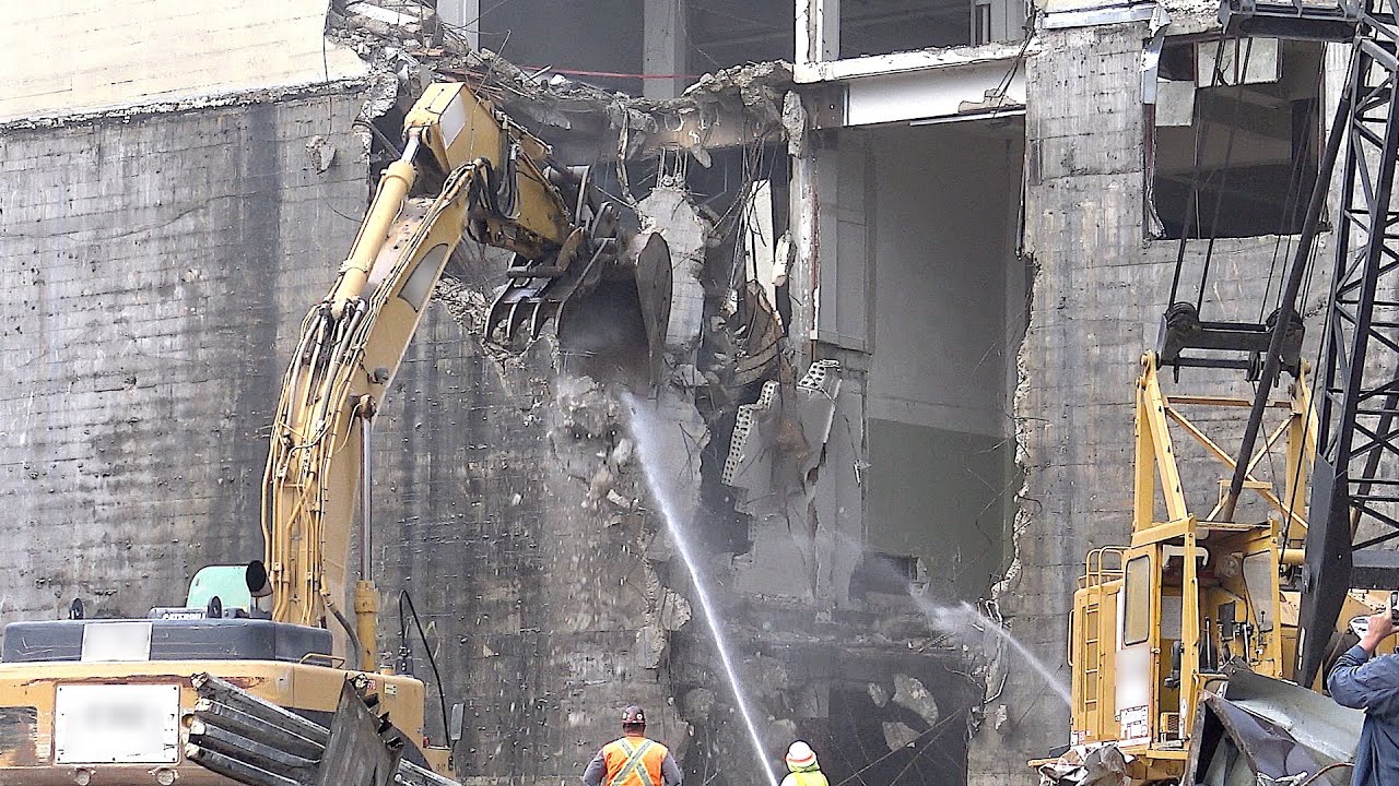 Demolition excavator demolishing part of a concrete (and steel) building