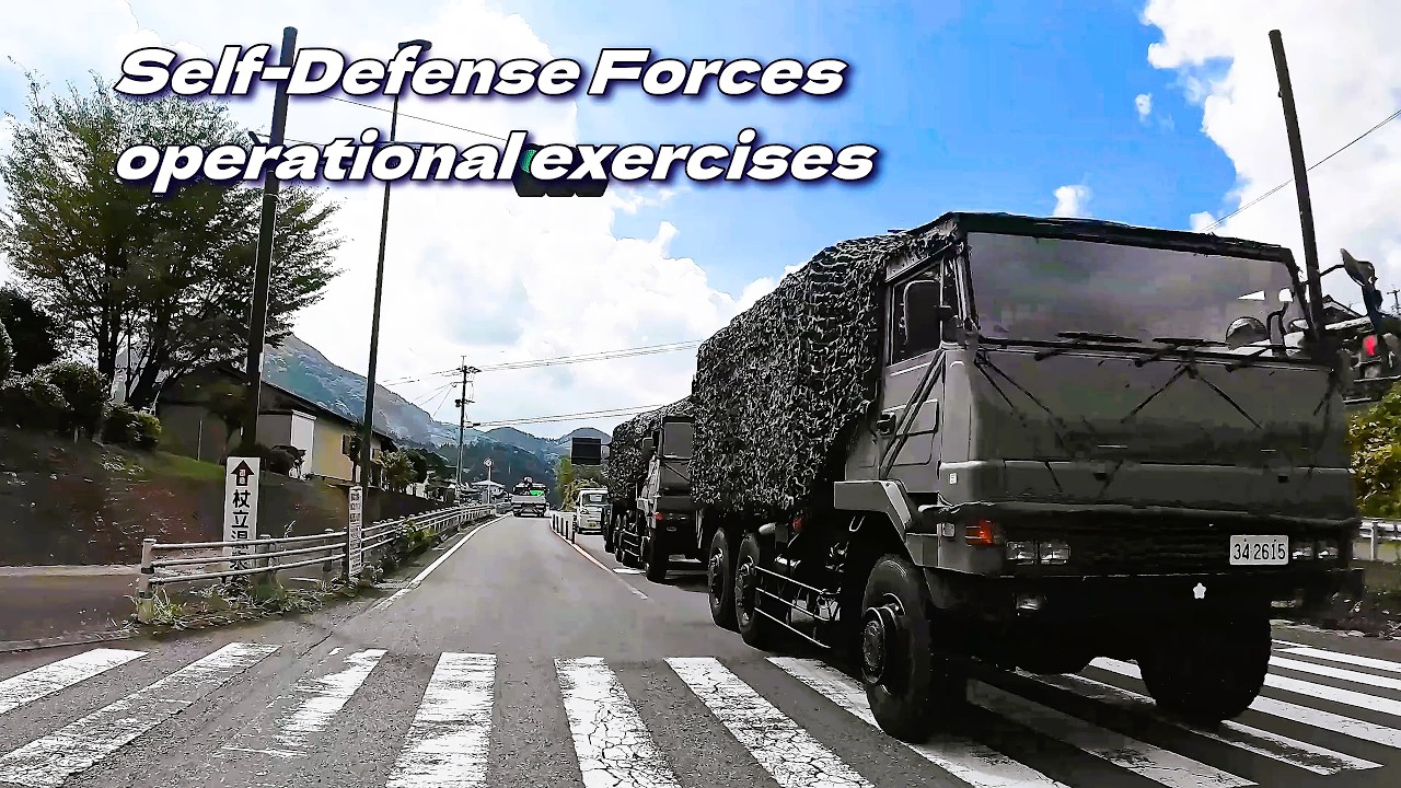 終わりなく続く、自衛隊車両群。「自衛隊統合演習」。A group of Self-Defense Force vehicles driving along a mountain road.