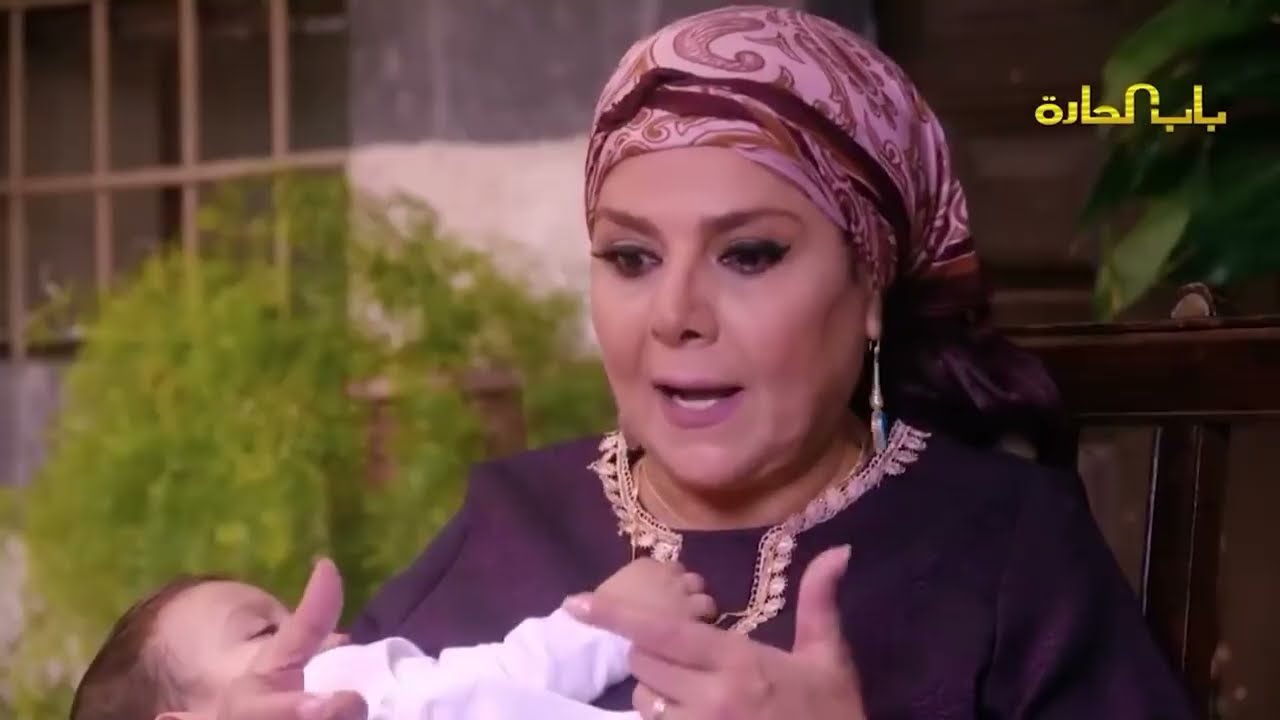 باب الحارة  ـ  سعاد شافت زوجها ابو عصام ماسك ولد صغير حاطينو جنب باب بيتهم