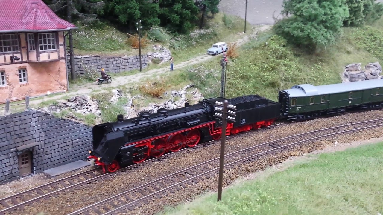 BR 19 017 in voller Fahrt durch den Bahnhof und auf der Strecke.