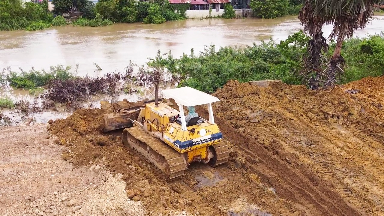 Powerful Komatsu D40P Dozer Pushing Soil to Prevent River Flooding