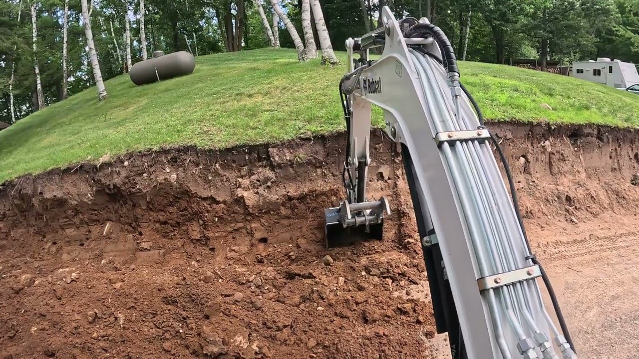 Bobcat E26 - Cutting hill for boulder retaining wall