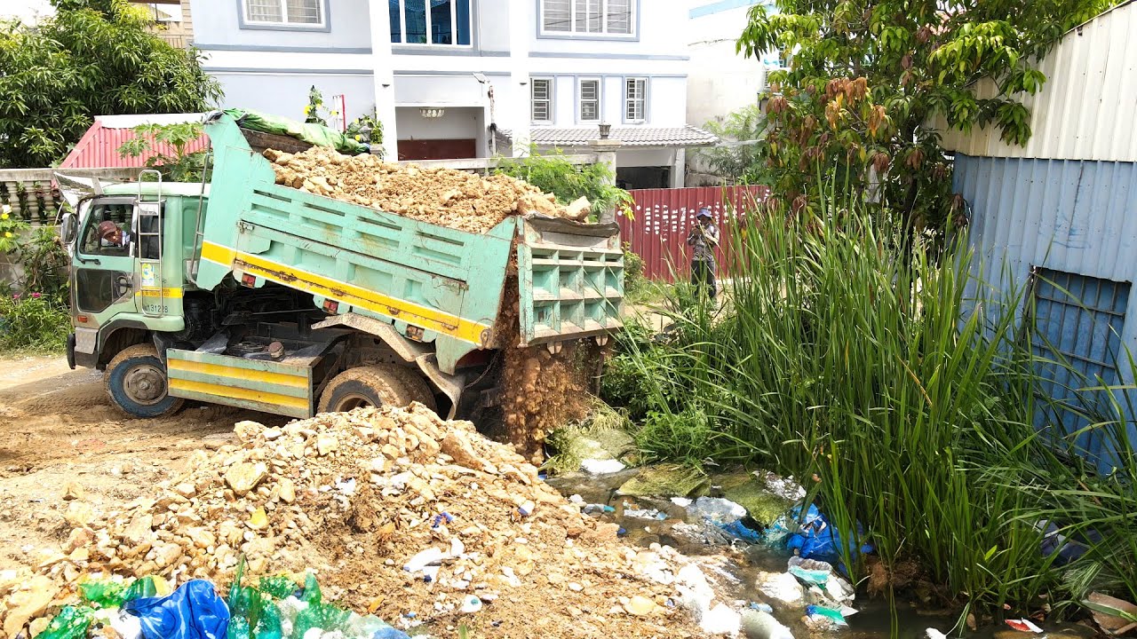 The Finish Project Pushing Rock to the dirty water and Grass growing in water by Bulldozer