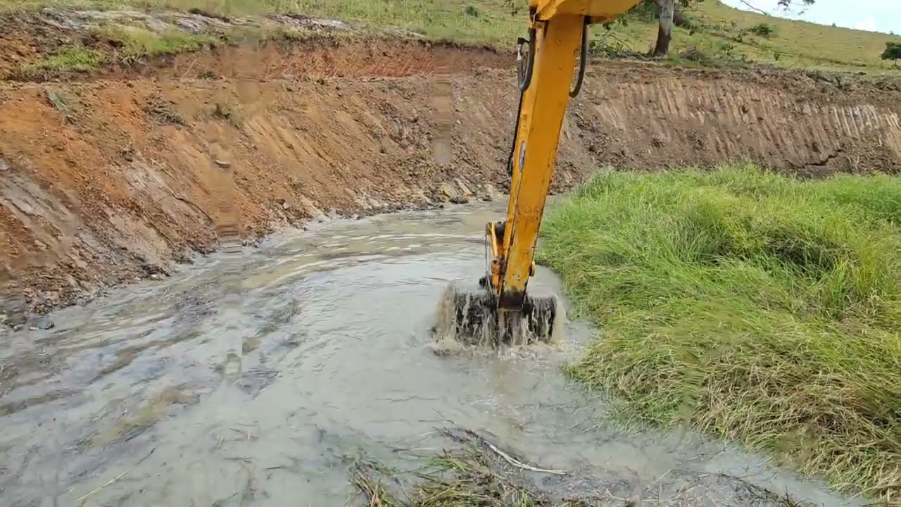 Escavadeira sendo auxiliada pela retroescavadeira