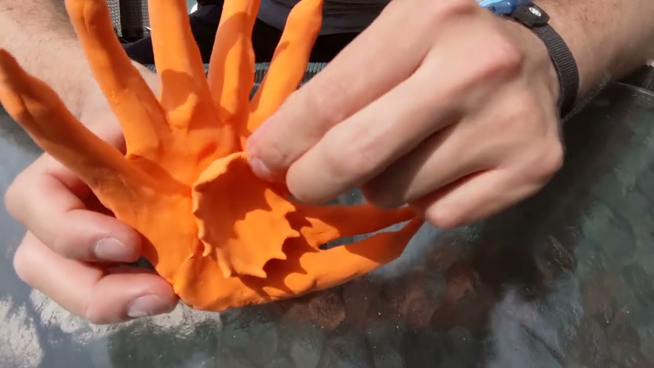 Making a statue sculpture out of orange colored clay 10