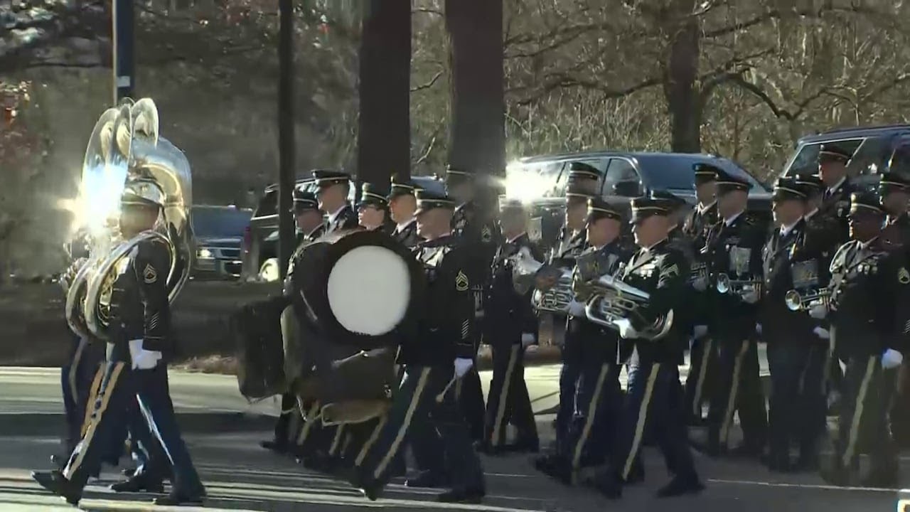 Military parade escorts Jimmy Carter motorcade to Carter Center